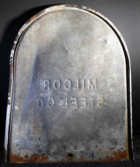 Interior of mailbox back plate with scar down left side from impact