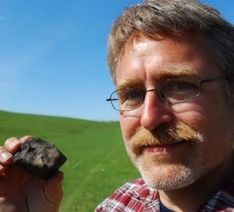 Karl Aston in the field with his find.  Photo credit Ed Treleven, State Journal.