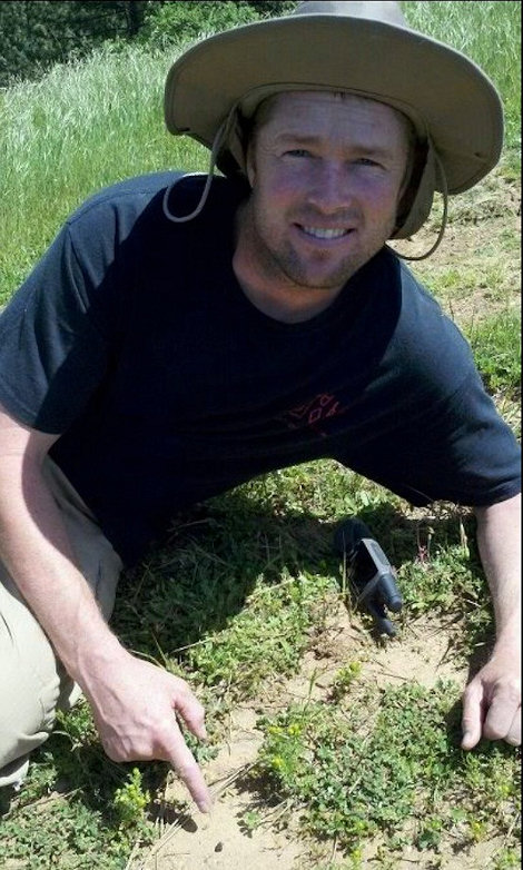 Robert with the smallest complete individual, 0.090 grams, in situ