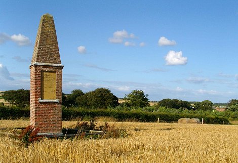 Historic monument at Wold Cottage, with the cottage at right in the tree line.  Photo by Martin Goff.